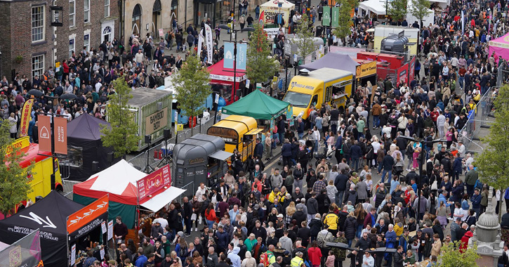 Aerial view of Bishop Auckland Food Festival, with crowds of people walking and browsing stalls